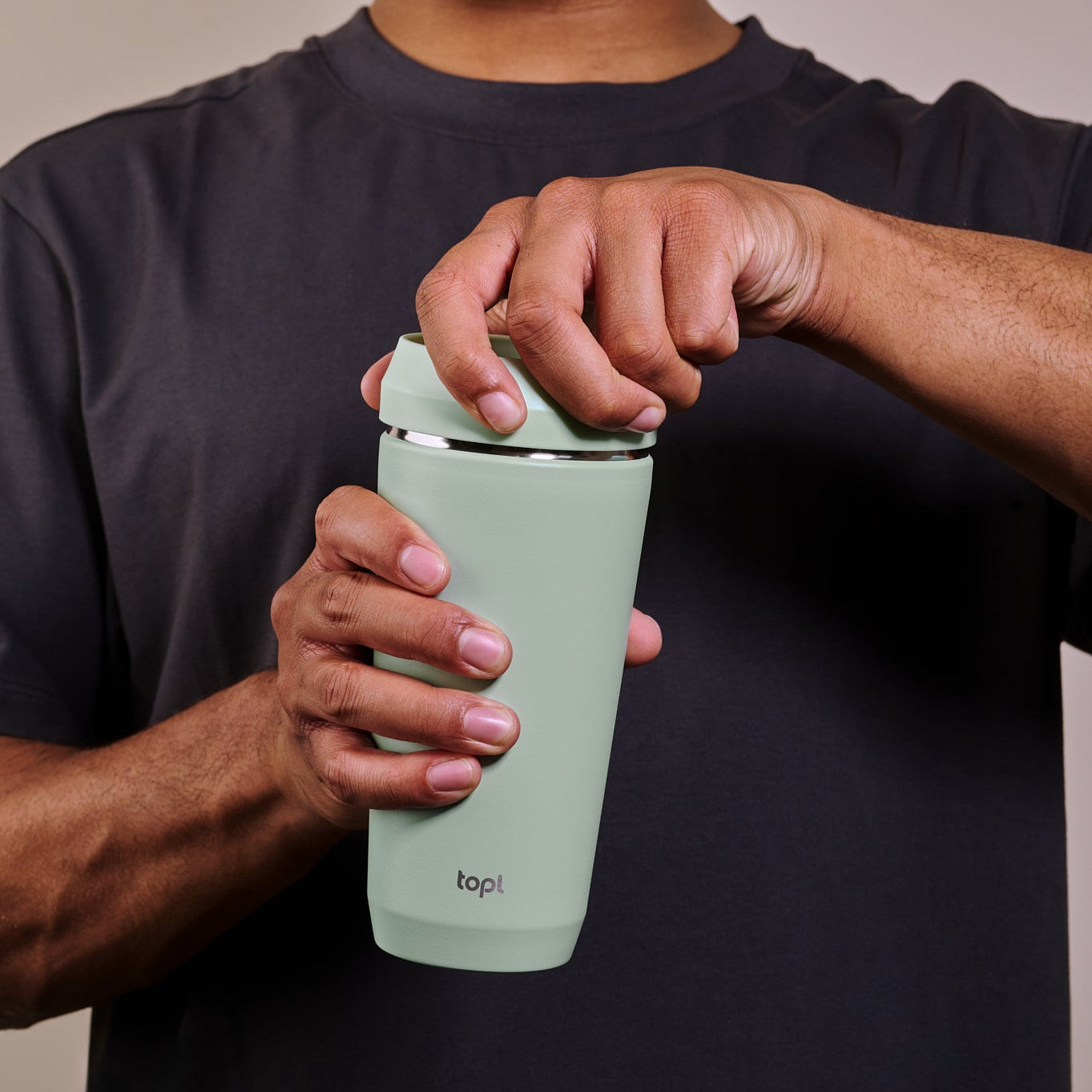 Man holding a mint green tumbler with 'kopr' branding against a neutral background