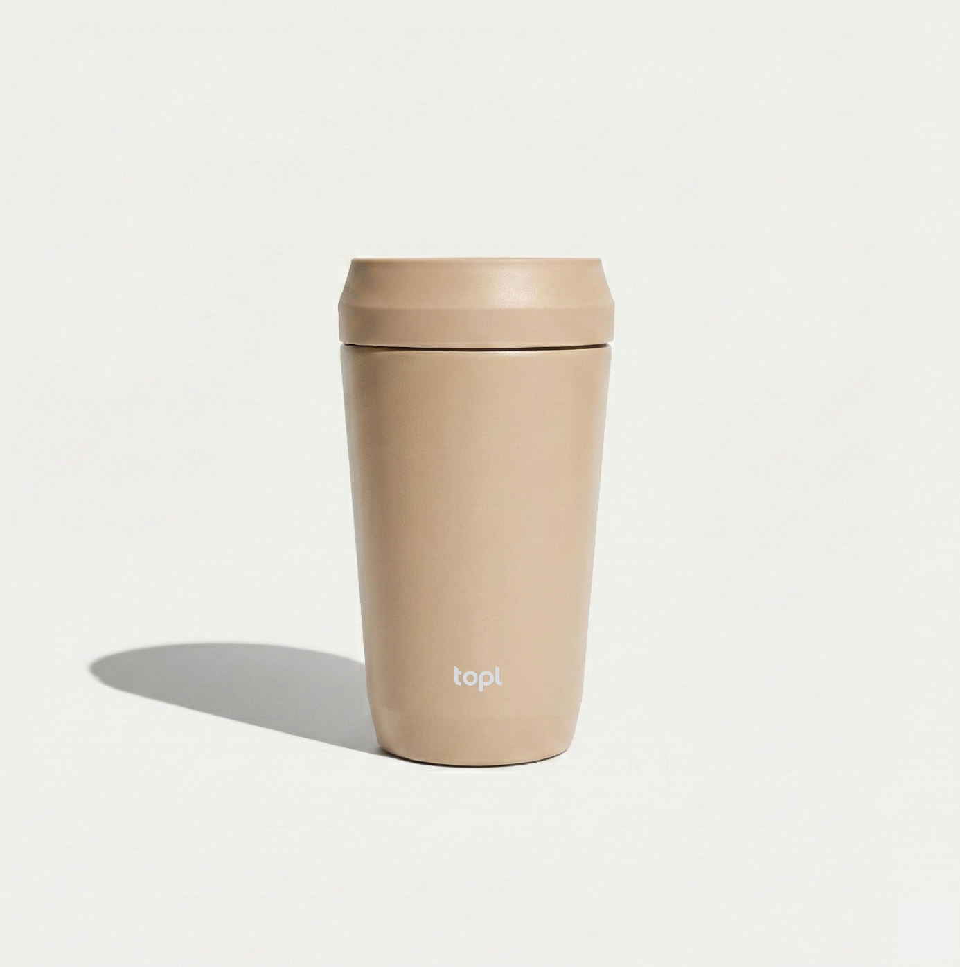 Beige tumbler with lid on a light gray background